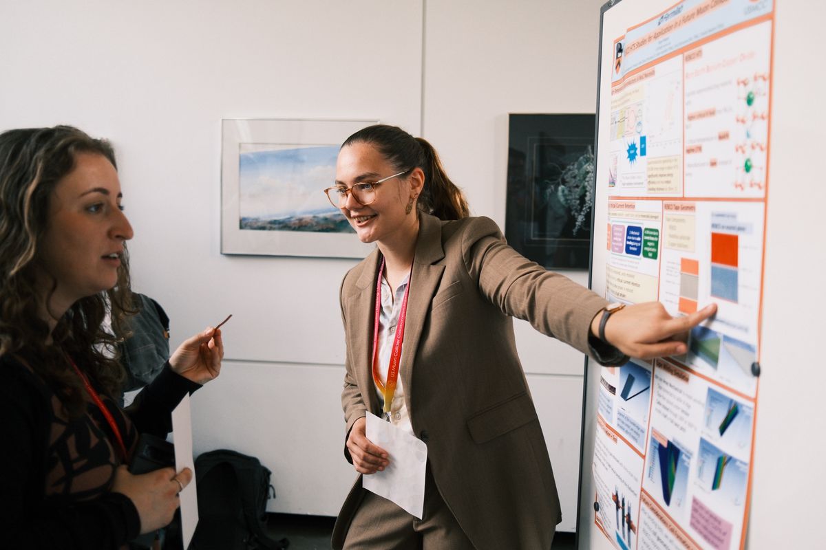 Two physicists at a poster on high-temperature superconductors